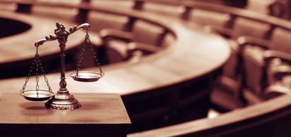 Leerer Gerichtssaal, im Vordergrund Waage der Justitia