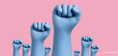 Nahaufnahme mehrerer erhobener Fäuste mit blauen Latexschutzhandschuhen auf rosa Hintergrund