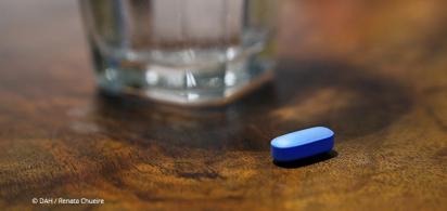 blaue Pille und ein Glas Wasser