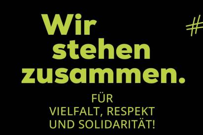 Blaue Schrift auf schwarzen Hintergrund: Wir stehen zusammen. F&uuml;r Vielfalt, Respekt und Solidarit&auml;t! Hashtag Aidshilfe Bleibt Stabil. Deutsche Aidshilfe