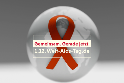 Eine Aidsschleife vor einer Weltkugel verdeutlicht das Thema des Spots: durch globalen K&uuml;rzungen droht Aids zur&uuml;ck zu kommen. 
