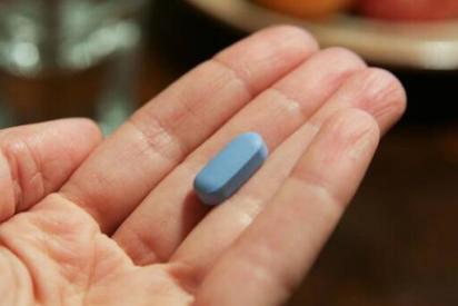 Hand mit blauer PrEP-Tablette
