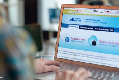 Frau surft mit ihrem Laptop auf der Website der Online-Beratung.